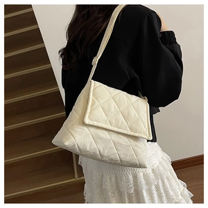 Close-up of white quilted crossbody bag with soft padded fabric and adjustable strap