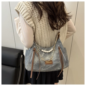 Detail of vintage grey washed tote with pearl chain and leather ribbon on the shoulder