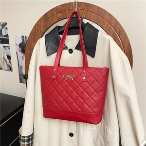 Red quilted tote bag with silver bow accent and shoulder straps for daily use