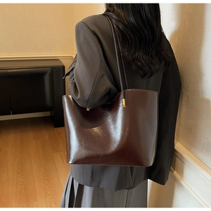Detailed back view of a high-quality leather tote bag shown on model in indoor setting