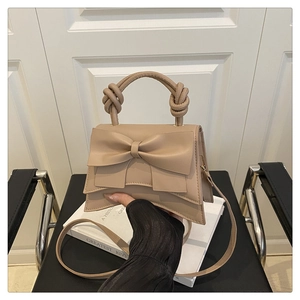 Detail of milk tea beige bow shoulder bag with knotted handle and detachable strap