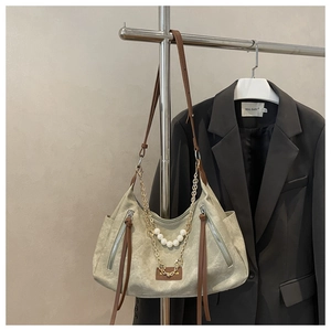Detail of canvas tote bag featuring pearl chains and double front zipper pockets