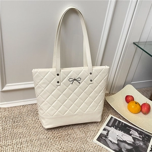 Quilted cream tote bag with silver bow detail and large capacity for daily commuting