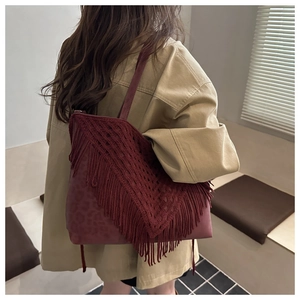 Detail of vintage burgundy tassel tote bag featuring leopard print texture and wide strap