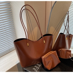 Close-up of caramel brown tote bag set with metal buckle detail and matching pouch