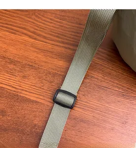 Detail of adjustable green nylon shoulder strap with smooth weaving and plastic buckle