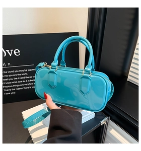 Detail of bright blue patent leather bag with a mirror finish and cylinder design