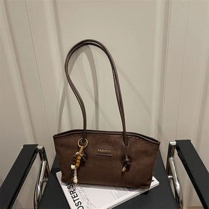 Retro coffee brown suede tote bag with leather straps and decorative beads on a chair