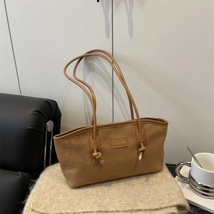 Brown faux suede tote bag with knotted cord straps and engraved fashion tag