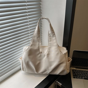 Sac fourre-tout minimaliste en toile crème avec design plissé sur un bureau de travail