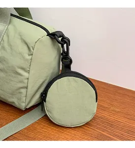 Detail view of a light green nylon bag with a matching circular coin purse attachment