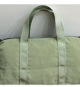 Close-up of light green nylon fabric texture and zipper detail on shoulder bag