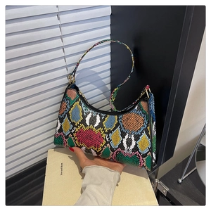 Detailed close-up of a crescent-shaped faux leather bag with colorful snakeskin pattern