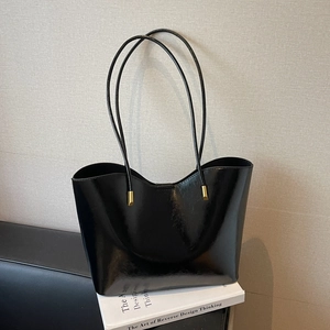 Glossy black oil leather tote bag with elegant wavy rim and gold hardware accents
