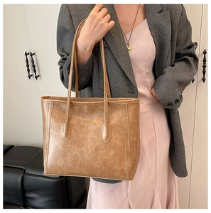 Close-up of vintage brown tote bag showing matte faux leather texture and dual handles