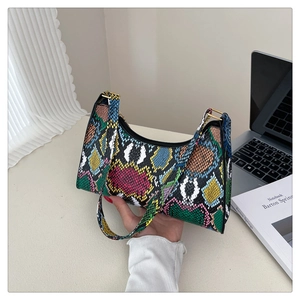 Detail of colorful snakeskin embossed mini handbag featuring premium gold metal hardware