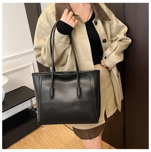 Detail shot of the large black tote bag in premium faux leather with long shoulder straps