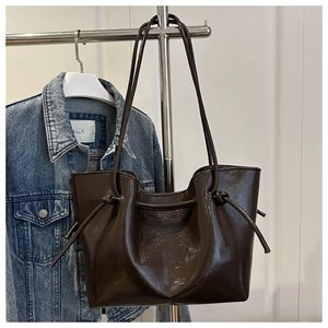 Dettaglio borsa shopper marrone scuro vintage con texture PU lucida e tracolla annodata