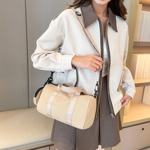 Close-up of lightweight khaki nylon cylinder crossbody bag with mini coin purse attachment
