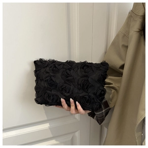 Detail of the 3D mesh rose petals texture on a black evening clutch bag for women