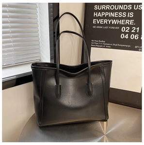 Close-up of black PU leather tote bag showing fine grain texture and sturdy strap details