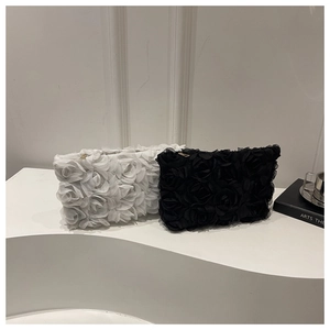 Close-up of elegant 3D lace rose petals and metal zipper on this designer evening clutch bag