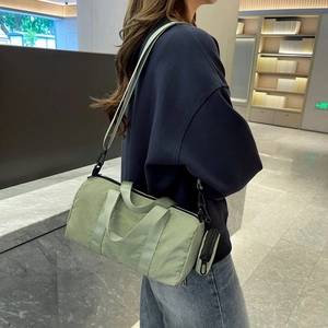 Detail of light green nylon cylinder bag with adjustable strap and small round pouch