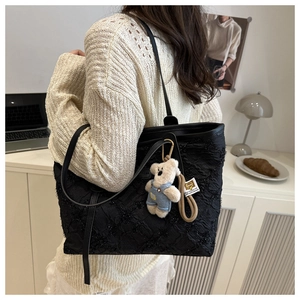 Dettaglio della borsa tote trapuntata nera con paillettes e ciondolo a forma di orso