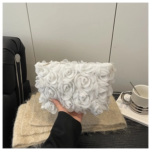 Detail of 3D rose floral clutch bag showing delicate white organza petals and texture