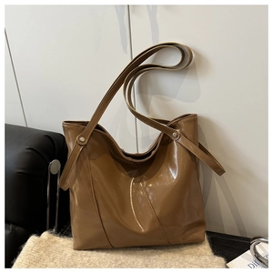 Detail of caramel brown glossy PU leather tote bag with elegant diagonal stitching detail
