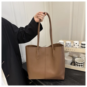 Détail d'un grand sac fourre-tout marron avec surpiqûres et longues bandoulières