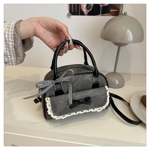 Détails d'un sac à main en jean gris avec nœuds noirs et bordure en dentelle blanche