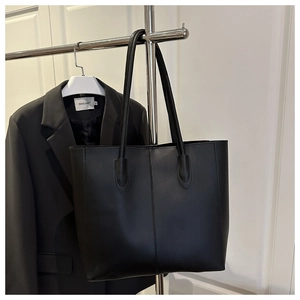 Vue détaillée du cabas minimaliste en cuir noir avec surpiqûres verticales
