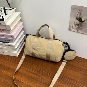 Detail of light khaki nylon cylinder bag with detachable coin purse and wide strap