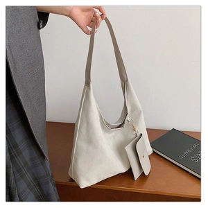 Detail view of cream canvas tote bag showing textured fabric and detachable coin purse pouch