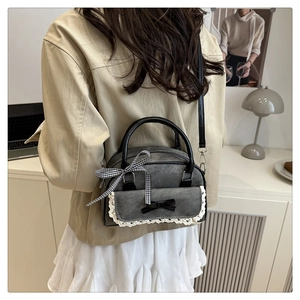 Vue arrière d'un mannequin portant un sac en denim gris avec dentelle et détails de nœud