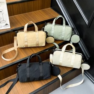 Detail view of nylon barrel bags in four colors with detachable strap and coin purse