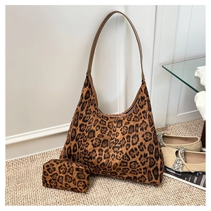 Detailed set of leopard print faux suede tote and matching pouch in indoor setting