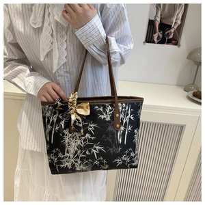 Detail of a chic tote bag featuring an oriental bamboo print and stylish silk scarf