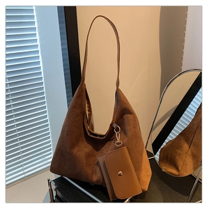 Detailed close-up of brown suede tote bag with wide strap and matching mini coin pouch