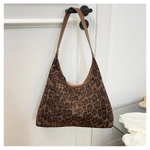 Detail shot of leopard print velvet tote bag with brown leather shoulder strap