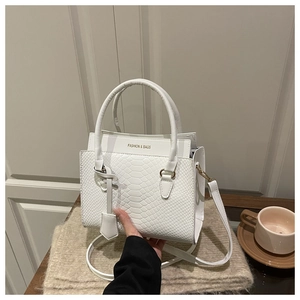 Gros plan sur la texture serpent blanc et le logo doré FASHION & BAGS du sac à main