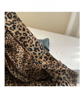 Close-up of leopard print canvas strap featuring a black adjustable plastic buckle