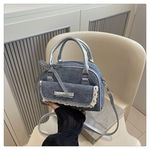 Détail d'un sac à bandoulière en denim rétro avec poche en dentelle et nœuds décoratifs