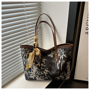 Detail of a black Chinese style tote bag with bamboo print and silk scarf on handle