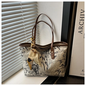 Detailed view of ink bamboo print on tote bag with leather handles and silk scarf decor
