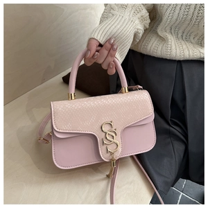 Detail of pink patchwork crossbody bag with snakeskin texture and golden tassel hardware