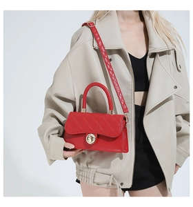 Vista detallada del bolso acolchado rojo con cierre dorado llevado por una modelo