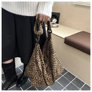 Detail shot of a large leopard print canvas tote bag worn on shoulder for daily styling