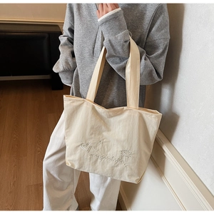 Détail du sac cabas en toile crème avec broderie de cœur et poignées renforcées